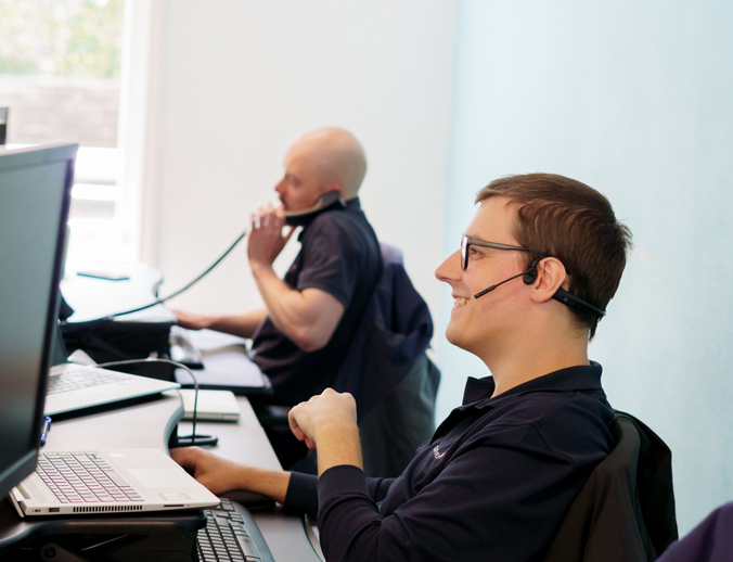 Two members of IT support staff on the phone